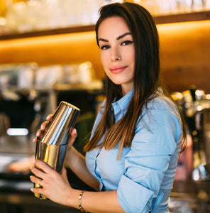  Female bartender shaking a drink with silver Boston cocktail shaker